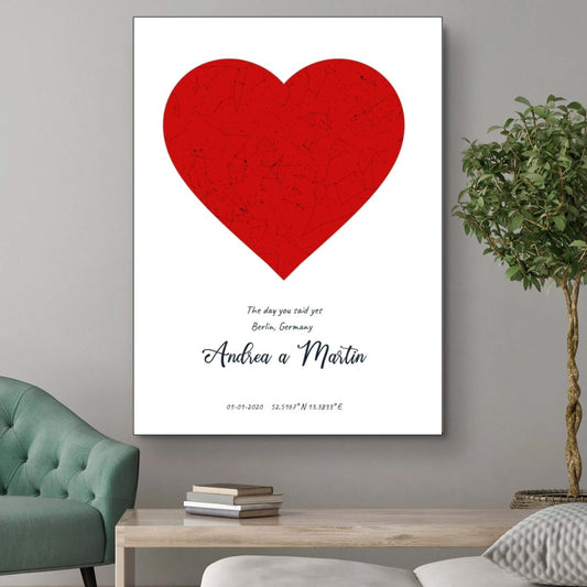 Heart-shaped star map artwork on canvas with personalized names and date, displayed in a living room setting.